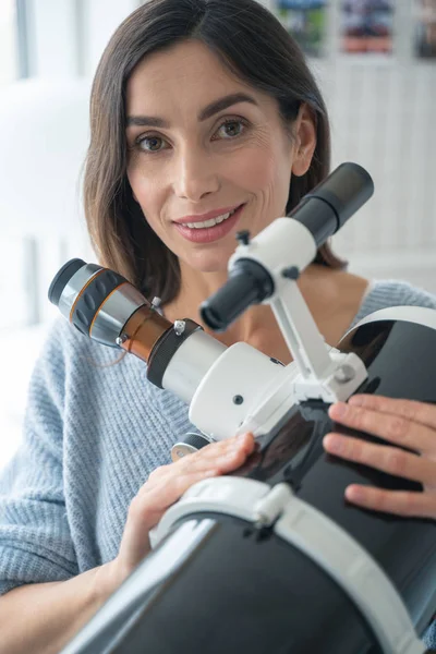 Smiling astronomer with telescope at home stock photo — Stock Photo, Image