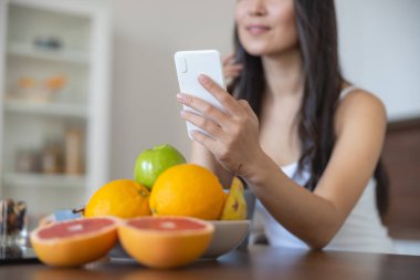 Dirseğini mutfak masasına dayayan bir kadın.