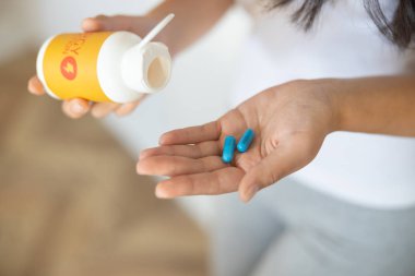 Kadın avucunda vitamin hapları var.