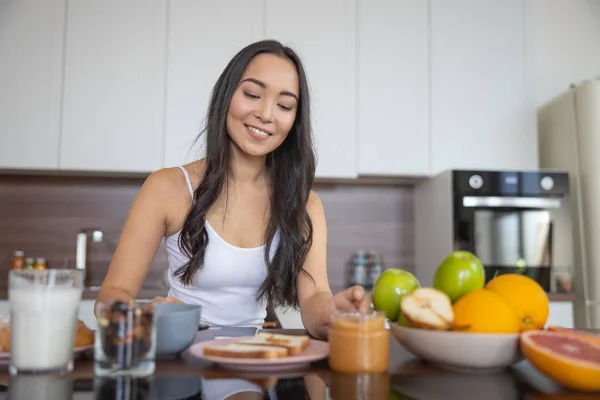 Fiatal nő reggelizik a konyhában — Stock Fotó