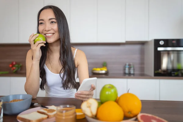 Mujer joven con un teléfono inteligente mirando hacia adelante — Foto de Stock