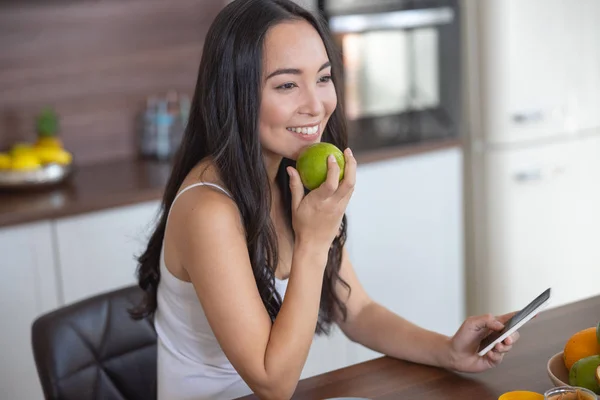 Chica con una manzana sentada en un sillón —  Fotos de Stock