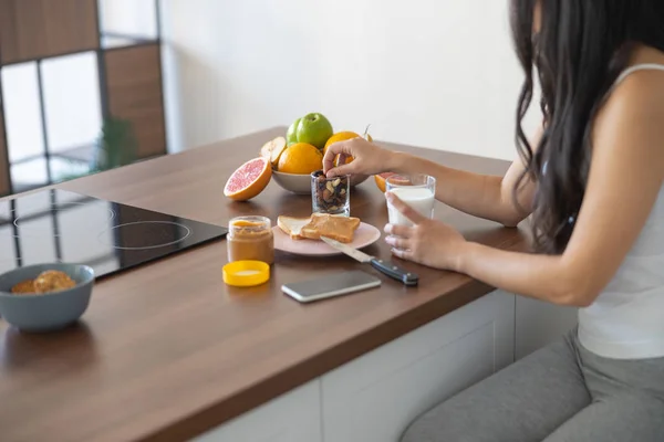 Joven asiática comiendo su desayuno en el interior — Foto de Stock