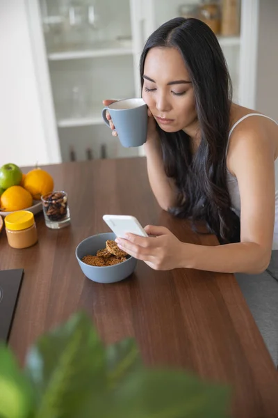 Young woman reading sad news at breakfast — Stock Photo, Image