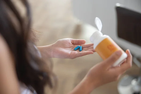 Menina com cápsulas de vitamina na palma da mão — Fotografia de Stock