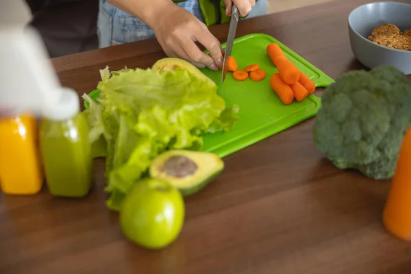 Mains féminines coupant des légumes sur la table — Photo