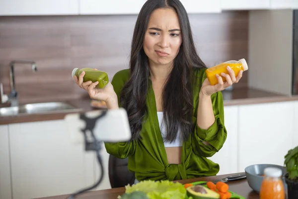 Annoyed dona de casa segurando duas garrafas de molhos — Fotografia de Stock