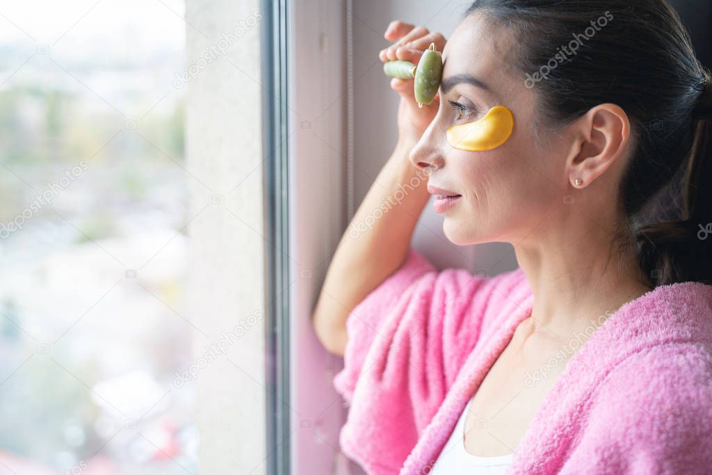 Woman massaging her forehead at home stock photo