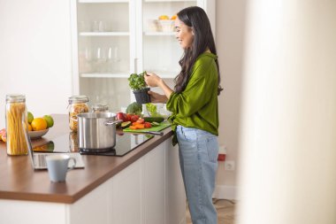 Fesleğen toplayan genç bayan.