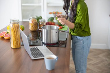 Asyalı kadın aşçı sebze çorbası yapıyor.