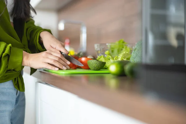 Dona de casa cortando tomates em uma placa de plástico — Fotografia de Stock