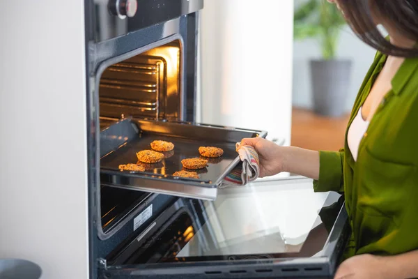 Young Asian housewife opening the convection oven — Stockfoto