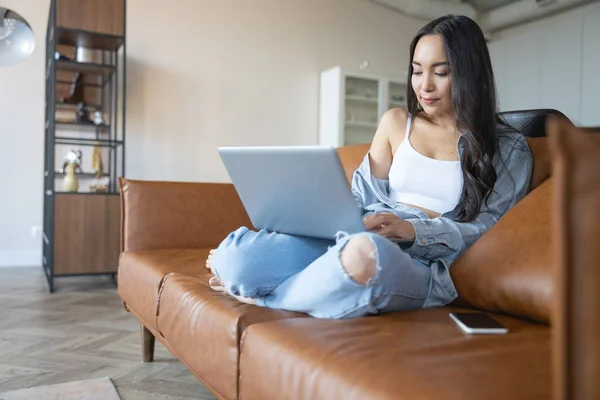 Mujer seria sentada en un sofá de cuero — Foto de Stock