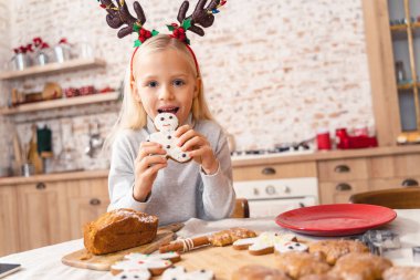 Tatlı küçük çocuk Noel kurabiyesi yiyor.