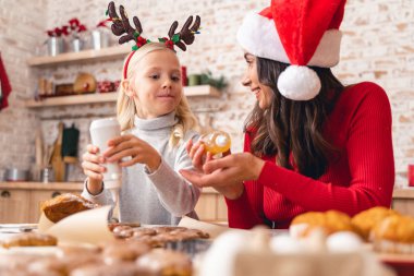 Neşeli genç kadın kızına bakıyor.