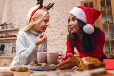 Sevimli kız neşeli annesine bakıyor.