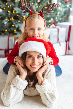 Küçük kız bir kadının sırtında dinleniyor.