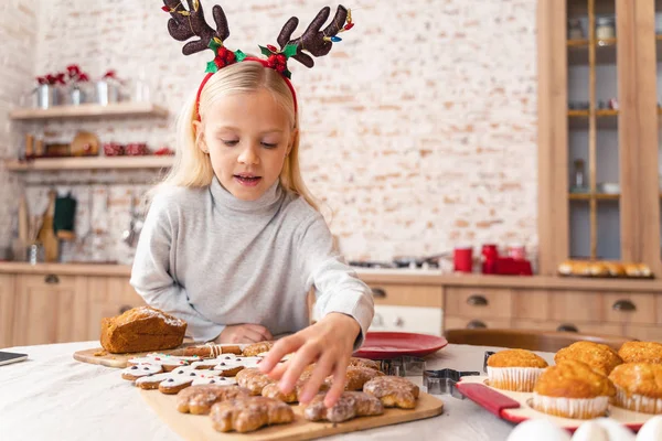 Mała dziewczynka pochyla się nad kuchennym stołem — Zdjęcie stockowe