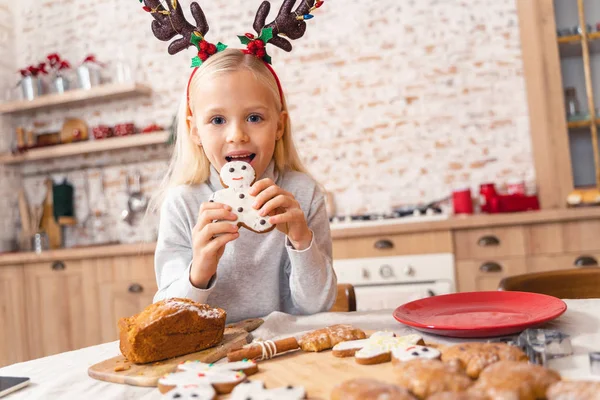 Söt liten unge äter en julkaka — Stockfoto