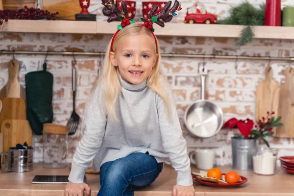 Meisje in een trui zittend in de keuken — Stockfoto