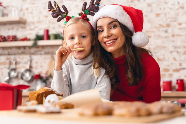 Όμορφη μικρή κυρία δοκιμάζει λευκή σοκολάτα Χριστουγεννιάτικα γλυκά — Φωτογραφία Αρχείου
