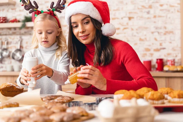 Enfant féminin mignon aidant sa mère heureuse — Photo