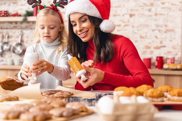 Lycklig mor och dotter dekorera julkakor — Stockfoto