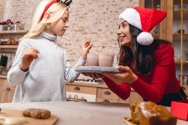 Mère joyeuse traitant son enfant au cacao chaud — Photo