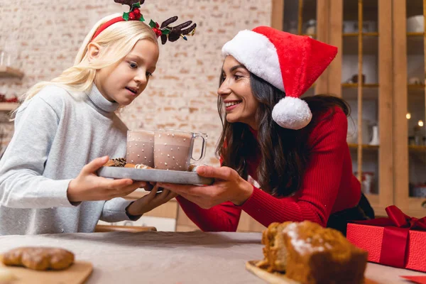 Lächelnde Mutter blickt ihre erstaunten Töchter an — Stockfoto