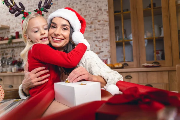 Lycklig härlig mamma kramar sin lilla dotter — Stockfoto