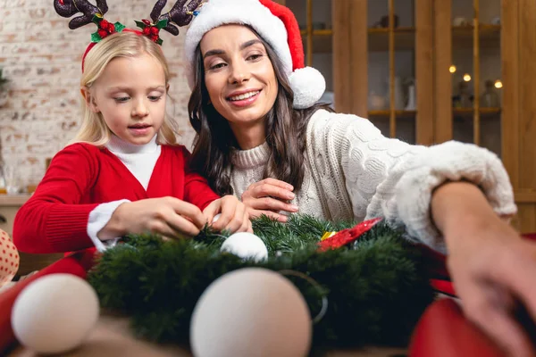 Donna soddisfatta seduta accanto alla figlia occupata — Foto Stock