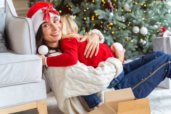 Ama de casa en un sombrero festivo abrazando a su hija — Foto de Stock