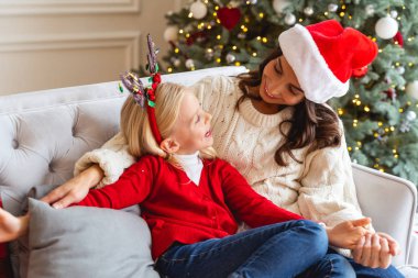 Neşeli kız gülümseyen annesine bakıyor.