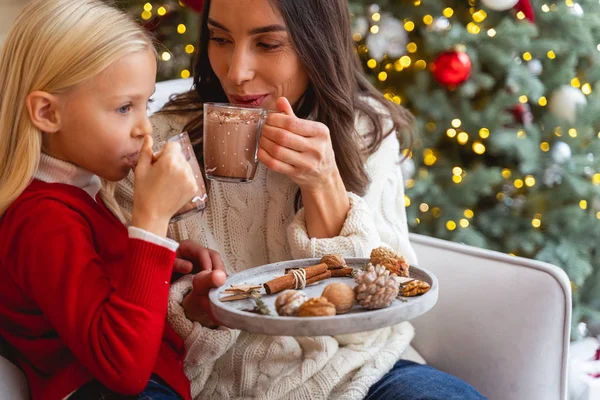 Mère avec une tasse en verre regardant sa fille — Photo