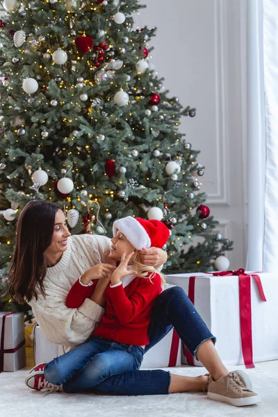 Mãe alegre olhando para sua menina Santa — Fotografia de Stock