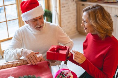 İki yetişkin insan hediye kutusuna bakıyor.