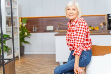 Kameraya gülümseyen neşeli yaşlı bayan.