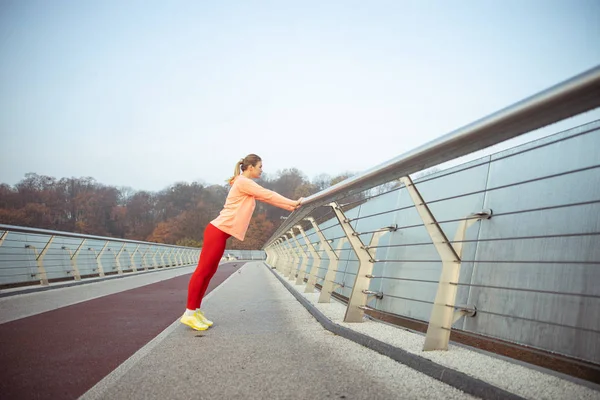 Sportig ung kvinna som motionerar på gatan — Stockfoto