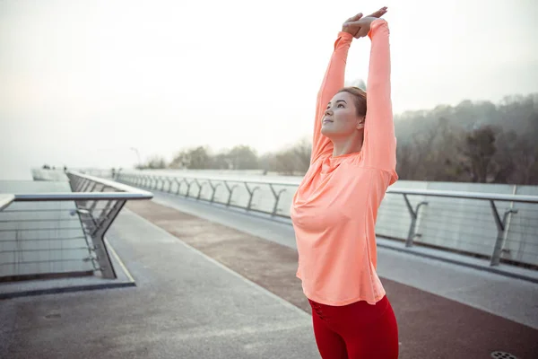 Mooie sportieve dame stretching op de straat — Stockfoto