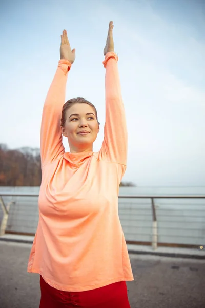 Bela senhora sorridente fazendo ginástica matinal ao ar livre — Fotografia de Stock