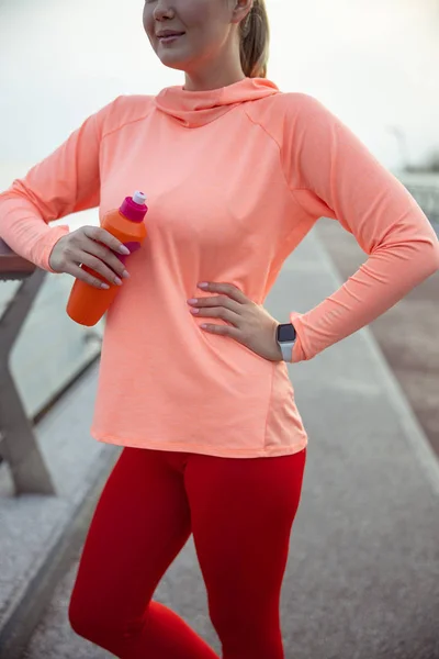 Joven sosteniendo botella de bebida deportiva — Foto de Stock