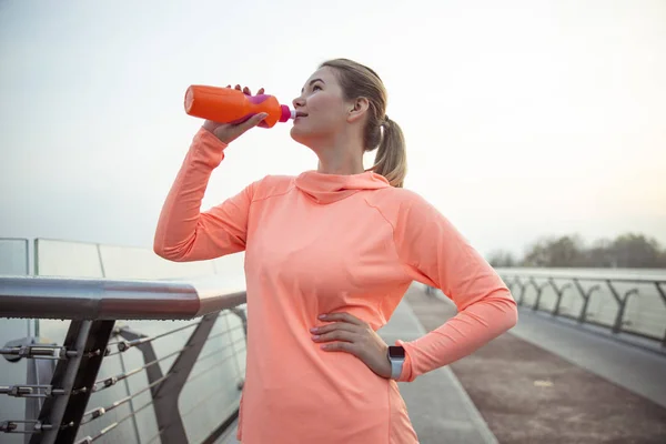 Bella signora sportiva che beve acqua per strada — Foto Stock