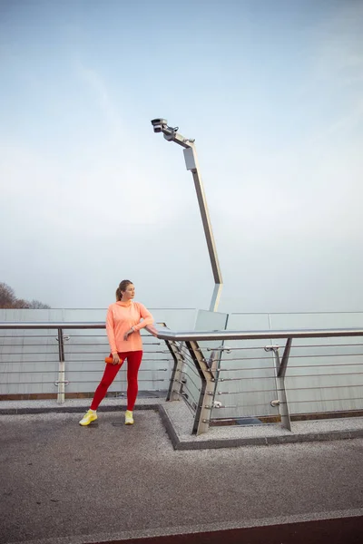 Signora in abbigliamento sportivo in piedi sul ponte — Foto Stock