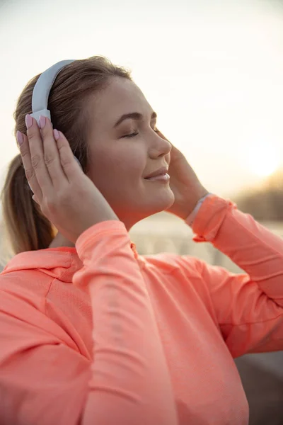 Красивая улыбающаяся женщина слушает музыку на открытом воздухе — стоковое фото