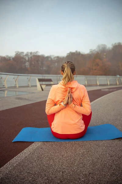 Jonge vrouw die yoga oefent op de brug — Stockfoto