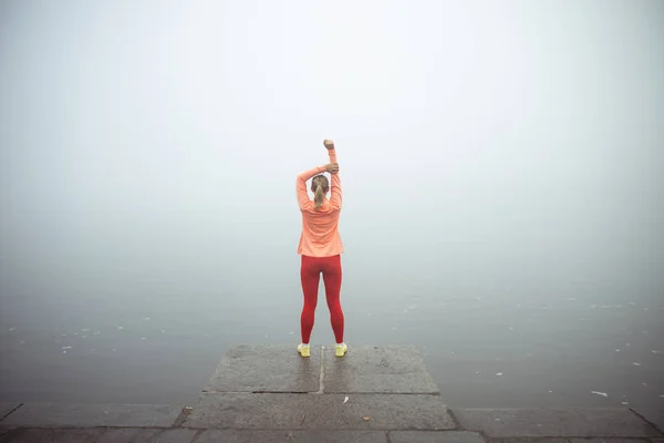 Sportovní mladá dáma stojící u řeky — Stock fotografie
