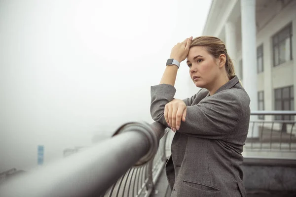 Pensive jonge vrouw die op het balkon — Stockfoto