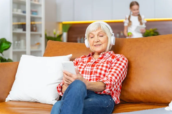 Senior lady listening to music in headphones — Stock Photo, Image