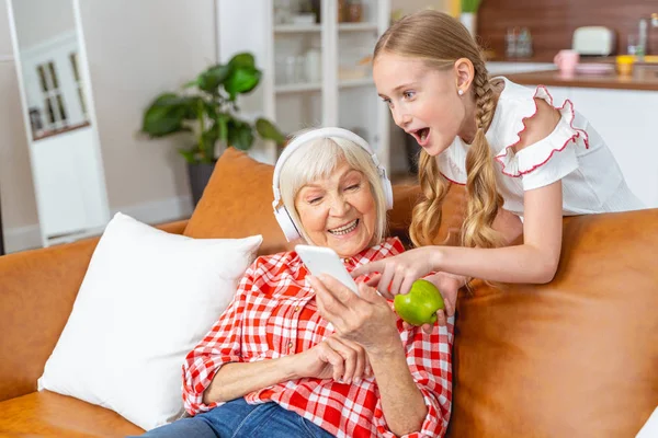 Atraktivní starší dáma ve sluchátkách srdečně se směje — Stock fotografie