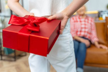 Arkasında bir hediye saklayan bir kadın.